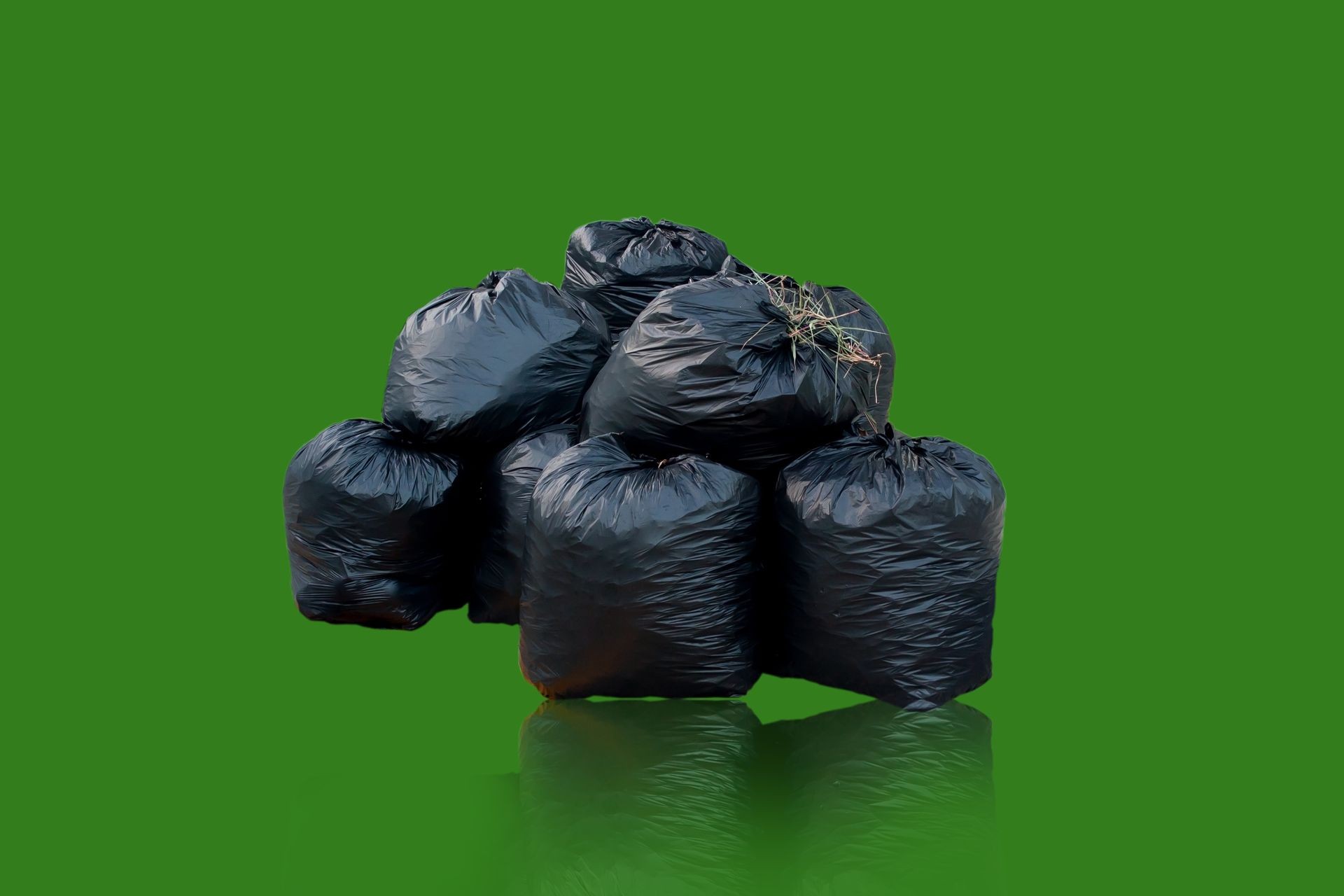 Black bag, garbage bag isolated from the green background,Black bag, garbage bag isolated from the background.