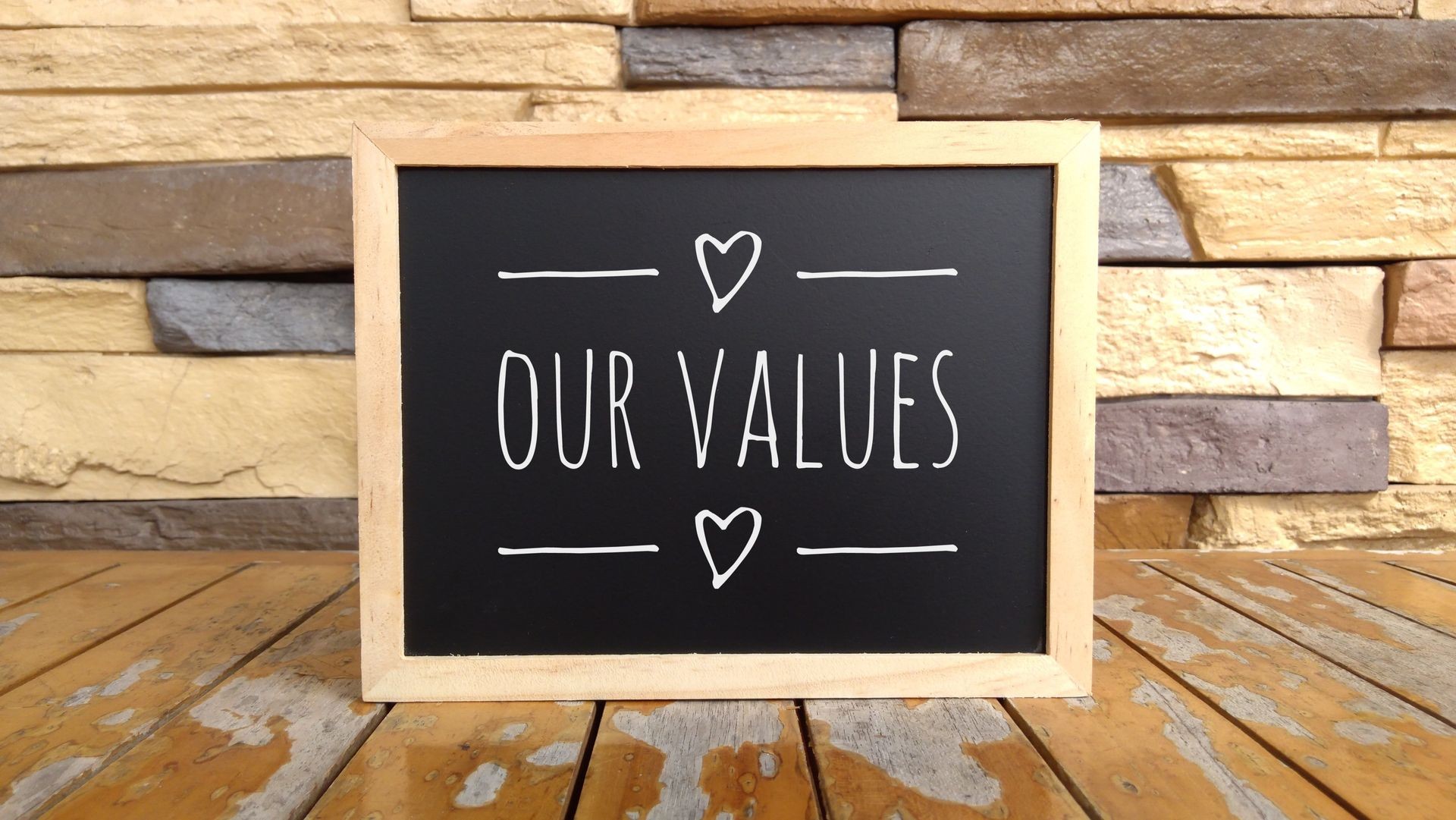 Business Concept - Chalk board with inscription our values on a wooden table.

